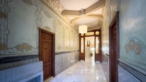 A hallway with marble flooring, ornate wall decorations, and a wooden door. - Nice flat for rent with large private terrace, next to Passeig de Gracia, Barcelona center (Barcelona)