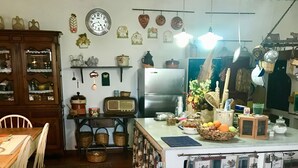 Een keuken met een koelkast, een radio en diverse decoratieve objecten aan de muur.