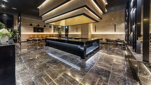 A modern kitchen with a central island, dark marble flooring, and contemporary lighting fixtures. - Yongin Astro Hotel (Yongin)