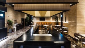 A modern hotel lobby with a long reception desk, seating area, and a large TV screen. - Yongin Astro Hotel (Yongin)