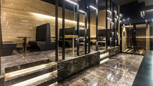 A modern lobby with marble flooring, black seating, and a reception desk. - Yongin Astro Hotel (Yongin)