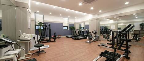 A modern gym with various exercise equipment, including treadmills, elliptical machines, and weight machines.