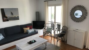 A living room with a sofa, a coffee table, two wicker chairs, a TV, and a cabinet. - 4 bedrooms Villa with pool, Sea view - 3 min walk to Binibeca vell (Binibequer)