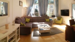 Un salon comprenant un canapé, une table basse et un coin repas avec des chaises et une table.
