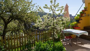 A garden with a wooden fence, a table with a tablecloth, and potted plants. - Cozy city apartment in Schwäbisch Hall (Schwäbisch Hall)