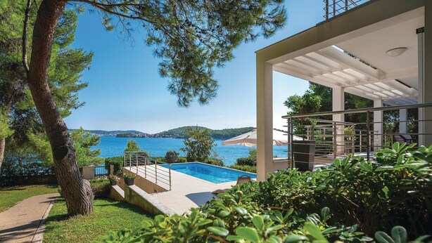 A modern outdoor pool area with a view of the sea and hills. - Lovely home in Rogoznica (Rogoznica)