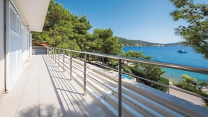 A balcony with a metal railing overlooking a coastal area with trees and a body of water. - Lovely home in Rogoznica (Rogoznica)