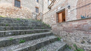 A stone staircase leading up to a building with a brick facade and a wooden door. - Nice home in Civitella Marittima GR (Civitella Marittima GR)