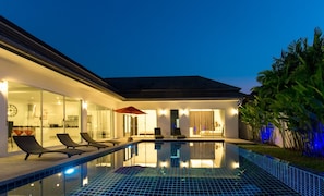 A modern house with a swimming pool, glass doors, and outdoor seating. - Kamala Contemporary 3 Bedrooms Pool Villa (Kamala)