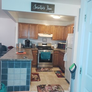 A kitchen with wooden cabinets, a stainless steel stove, and a refrigerator.