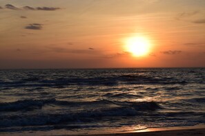 A sunset over the ocean with waves.