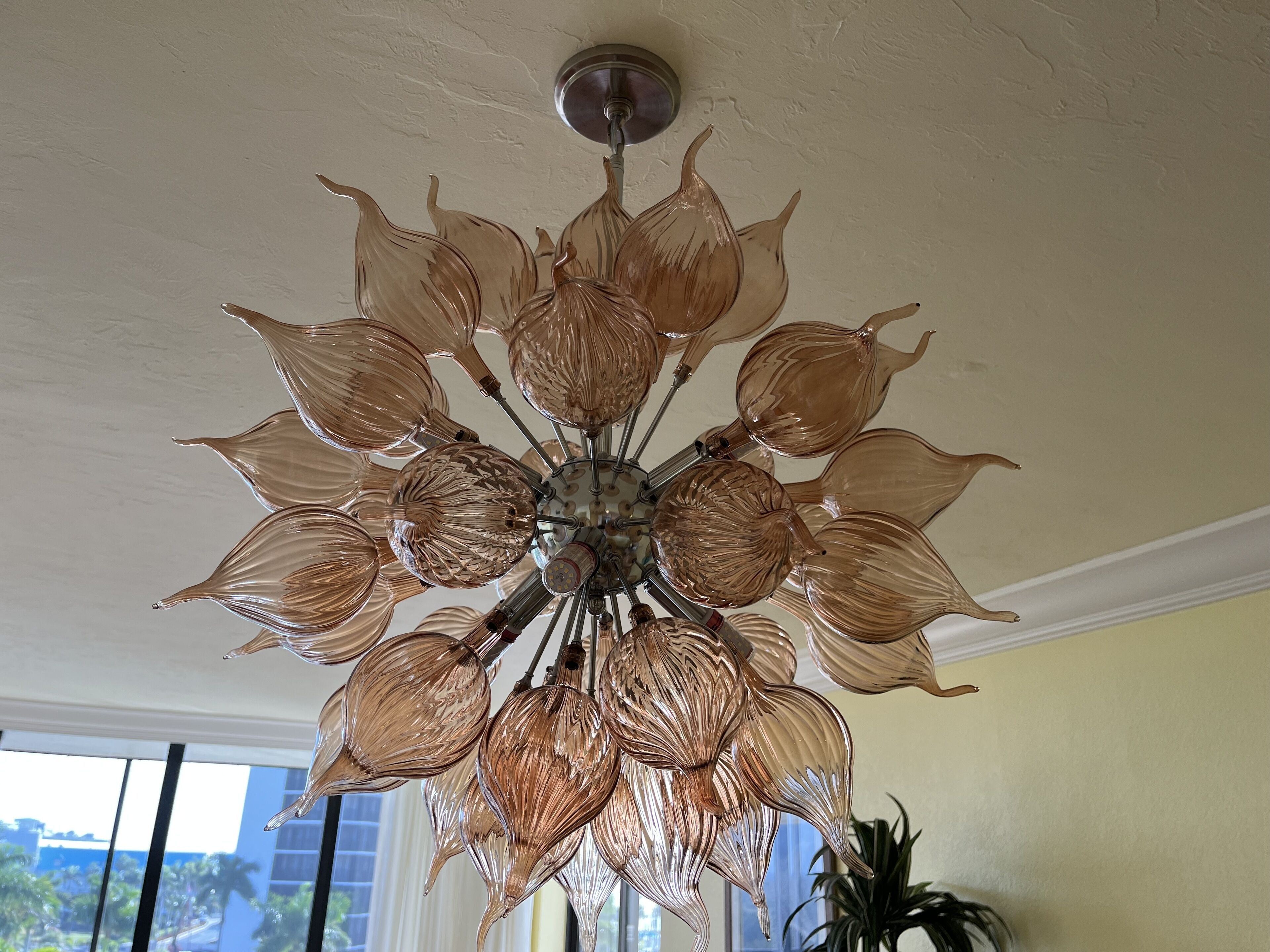 Un candelabro con una lámpara central rodeada de múltiples pantallas de cristal.