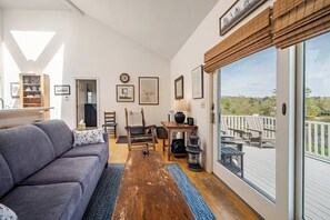 A cozy living room with a sofa, chairs, a table, and a view of the outdoors. - Contemporary Cottage With Spectacular Ocean Views And Access (Bristol)