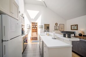 Une cuisine moderne dotée d’un îlot central, d’un four encastré et d’un garde-manger.