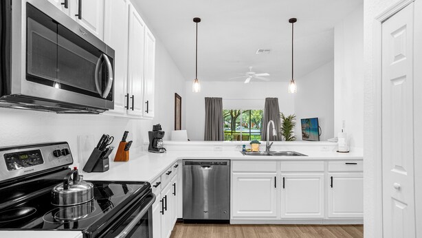 A modern kitchen with white cabinets, stainless steel appliances, and a dishwasher. - Bahama Bay, Davenport, Florida Oversize 2 Br condo (Davenport)
