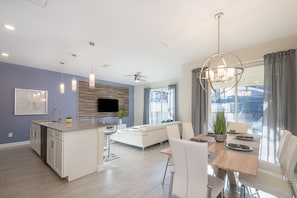 Enjoy a spacious living area with a dining table and comfortable seating, a kitchen with a dishwasher and sink, and a cozy seating area with a fireplace.