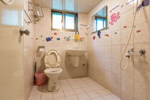 Une salle de bain équipée de toilettes, d’un lavabo et d’une douche.