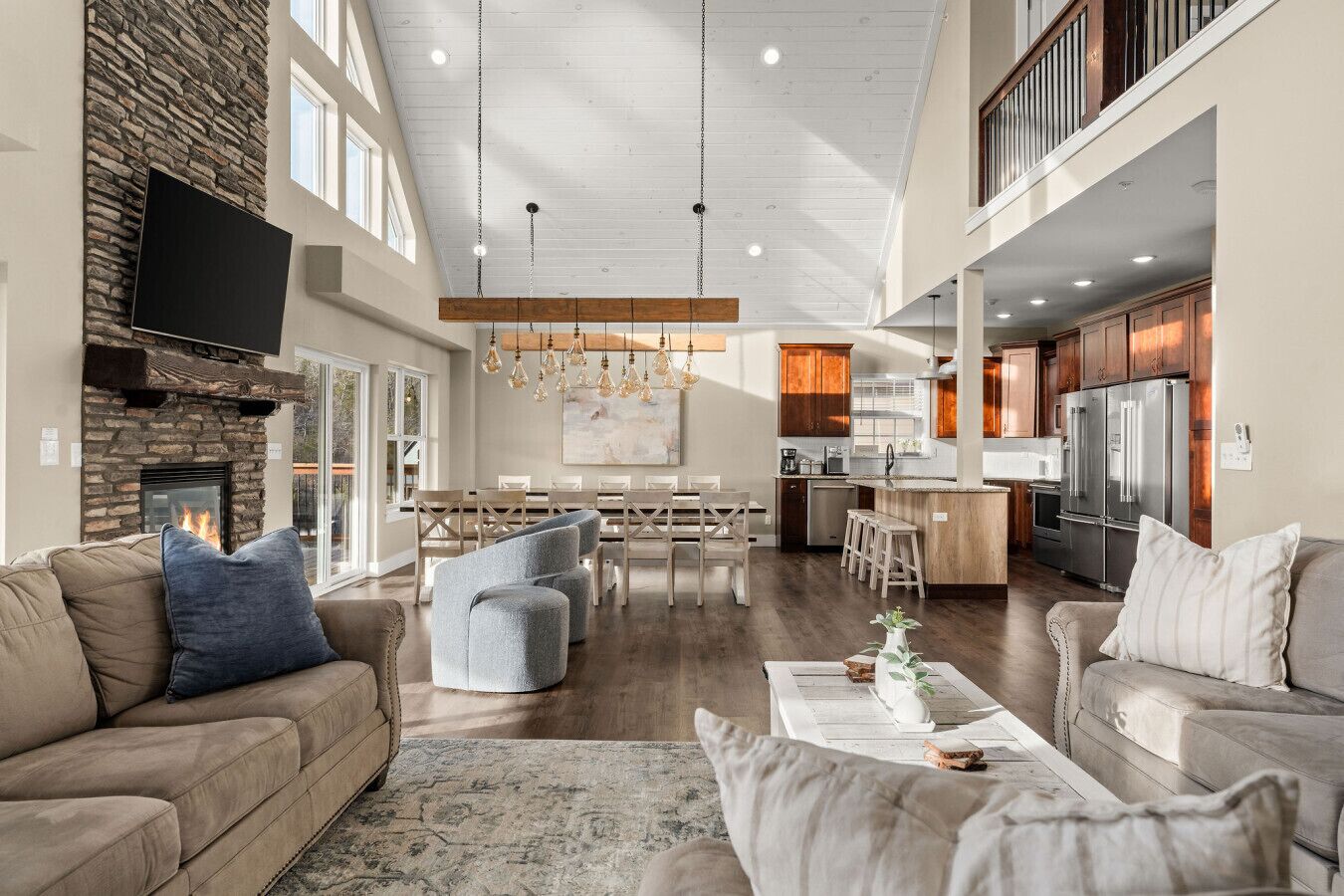 A spacious living room with a fireplace, a dining area, and a kitchen with modern appliances.