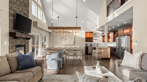 A spacious living room with a fireplace, a dining area, and a kitchen with modern appliances.