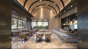 Un restaurante moderno con techo curvo, ventanas amplias y suelo de mármol.