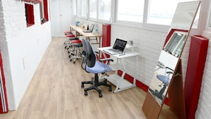 A modern office space with white brick walls, red accents, and large windows. - Photo Park Guesthouse (Seoul)