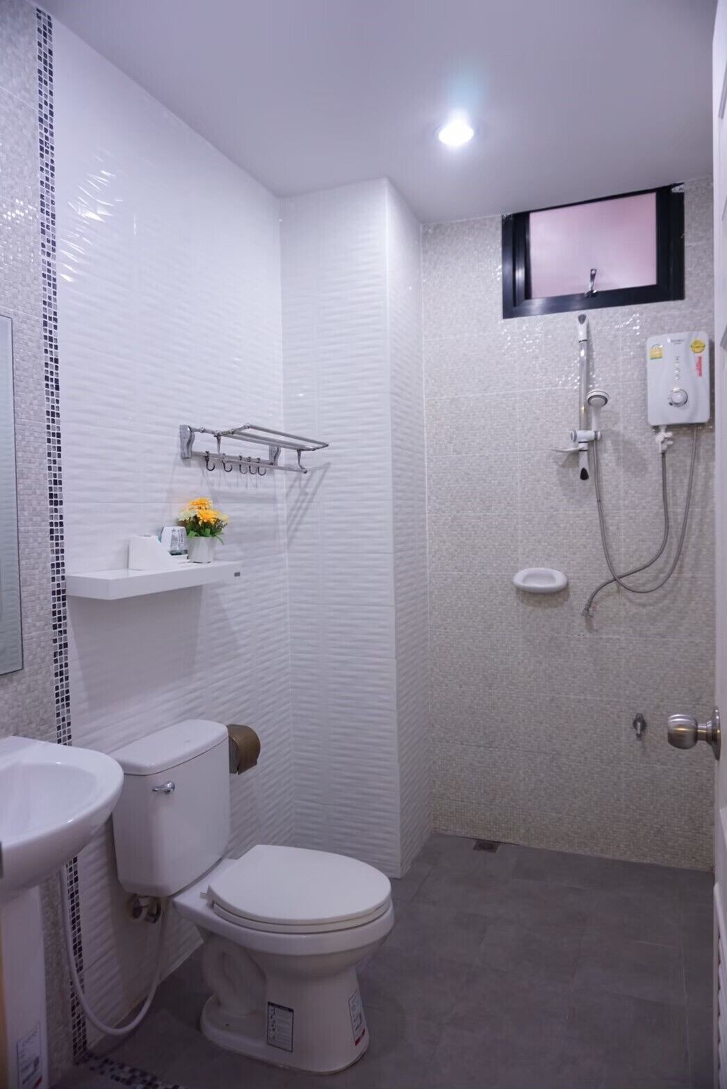 A modern bathroom with a toilet, sink, and shower.
