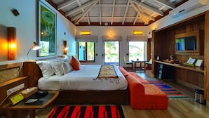 A spacious room with a large bed, a desk, and a television. There are windows providing natural light and a view of the outdoors. - Mermaid Beach Resort (Cox's Bazar)
