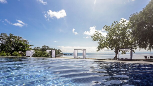 A clear blue pool with a view of the sea and a gazebo. - Cala Laiya (San Juan)