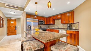 Una cocina con armarios de madera, una isla central y un microondas.