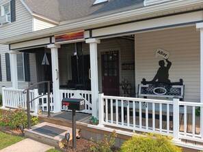 A house with a porch, a mailbox, and a silhouette sign.