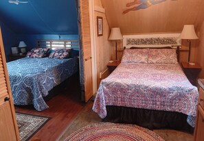 Une chambre avec deux lits, chacun agrémenté de draps à motifs et de lampes de chevet.
