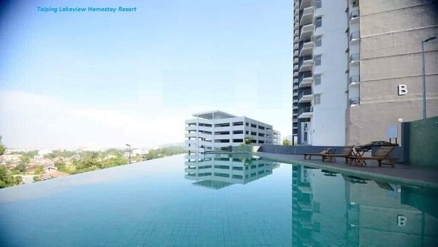 Un edificio moderno con piscina y zona de descanso en la azotea.