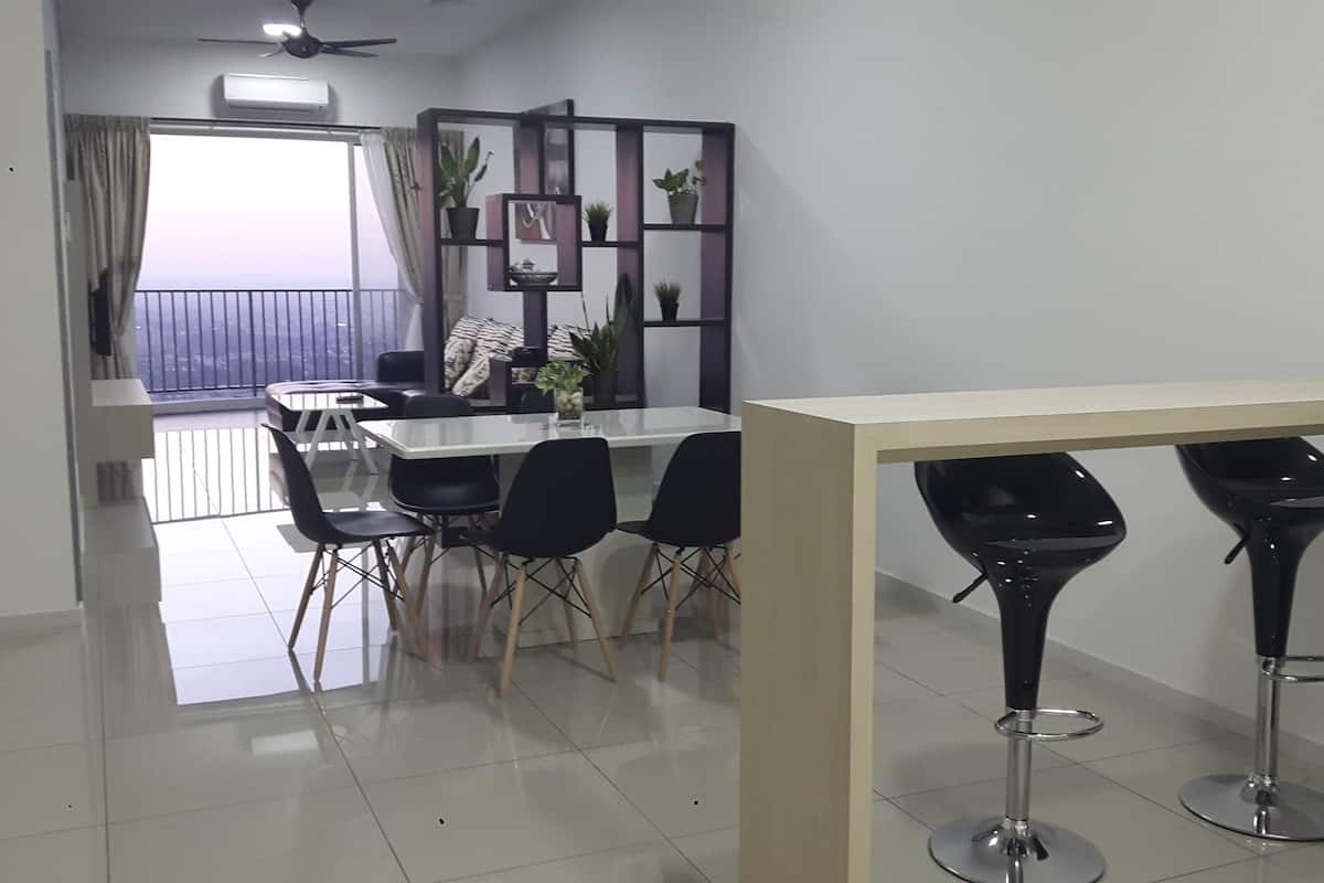Un comedor moderno con una mesa blanca y sillas negras, un taburete negro y vistas a un balcón con cortinas.
