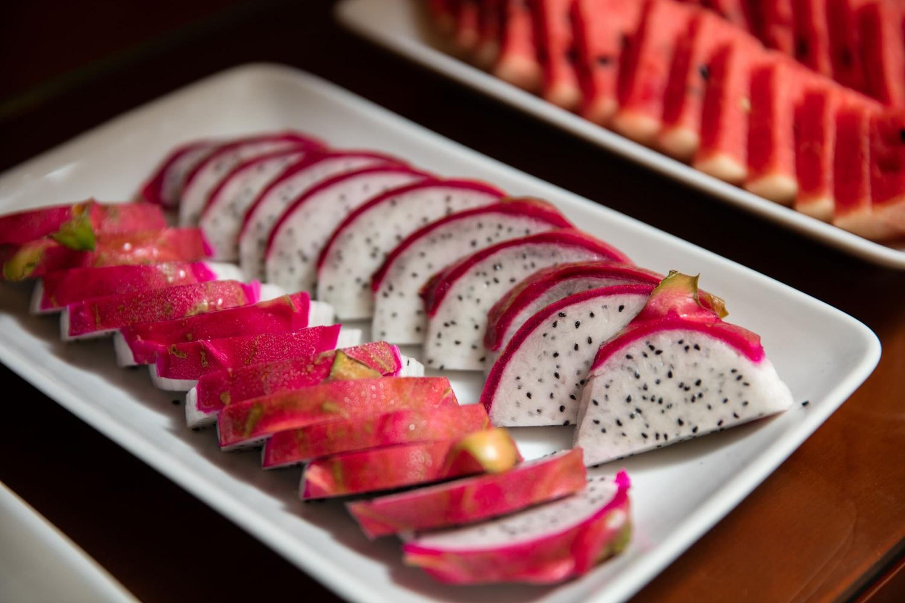 A white plate with sliced dragon fruit and watermelon.
