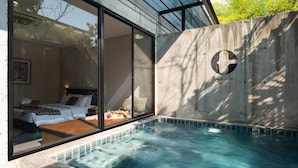 A modern hotel room with a large sliding glass door, a private balcony, and a hot tub. - Cherlock Hotel (Chiang Mai)