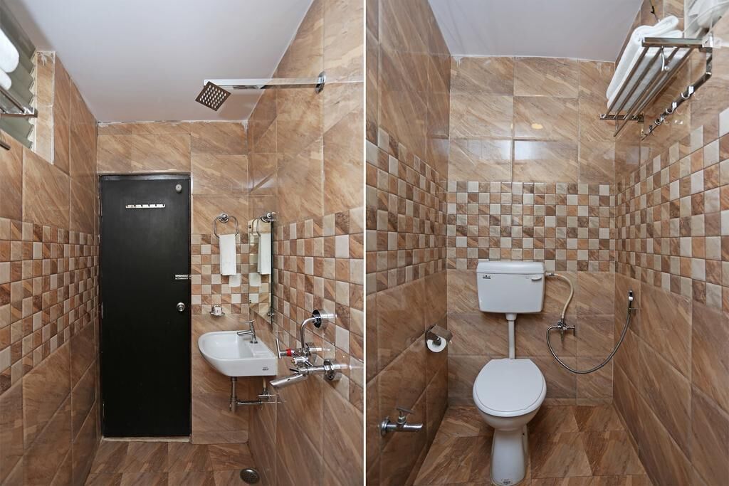 Een badkamer met een zwarte deur, een wastafel, een toilet en een douchehoek.
