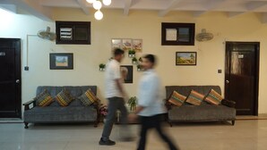 A room with two sofas, a ceiling fan, and wall-mounted air conditioning units. - Hotel Sahu Near Kashi Vishwanath Temple Gate (Varanasi)