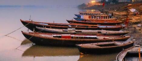 A row of boats docked along a riverbank.