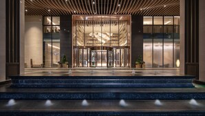 A modern hotel entrance with a revolving door, a glass facade, and a tiered entryway. - Holiday Inn Foshan Shunde (Foshan)
