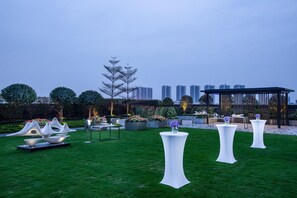 A rooftop garden with white tables, a gazebo, and modern sculptures. - Holiday Inn Foshan Shunde (Foshan)
