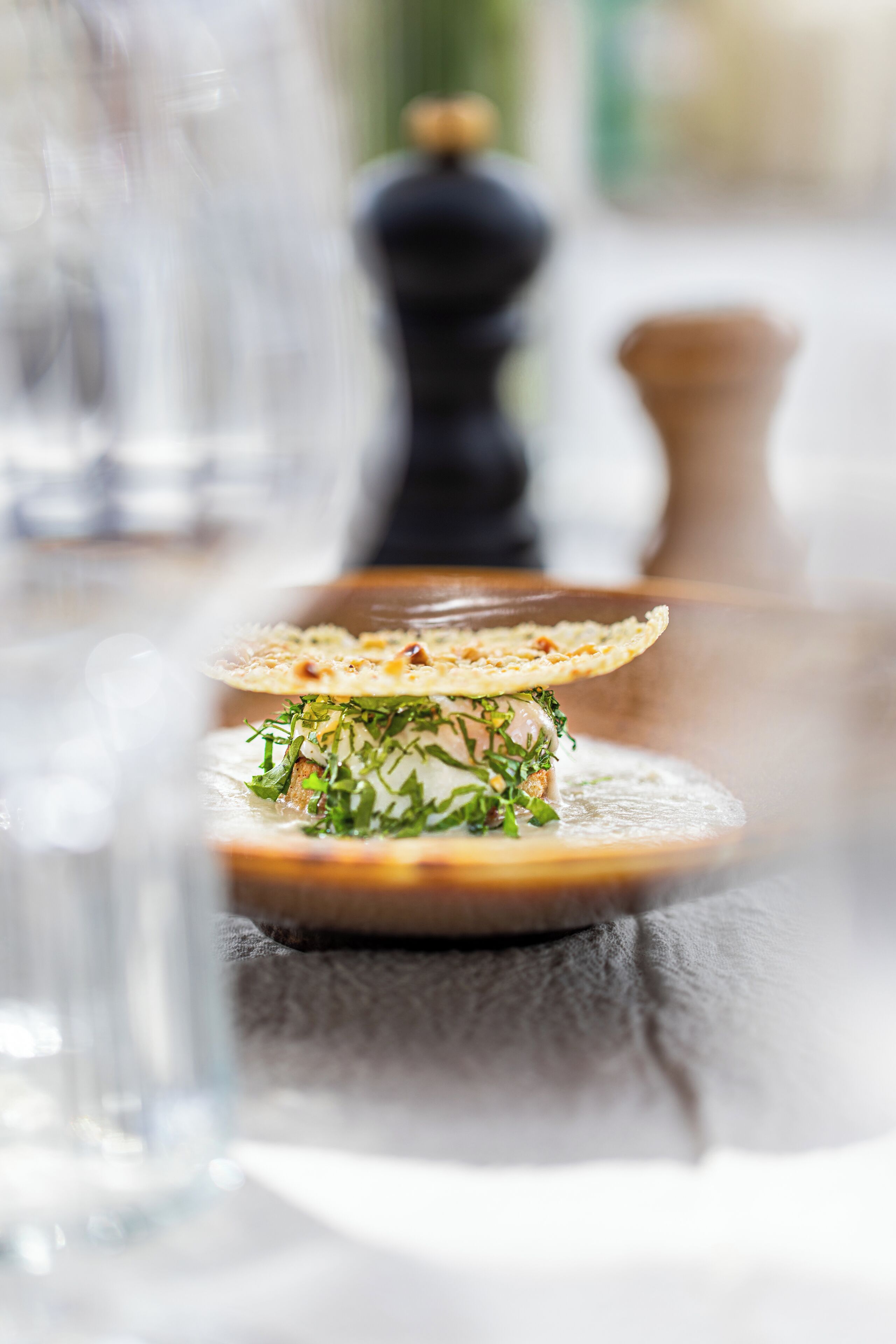 A close-up of a dish with a crispy edge, garnished with herbs, on a round plate.