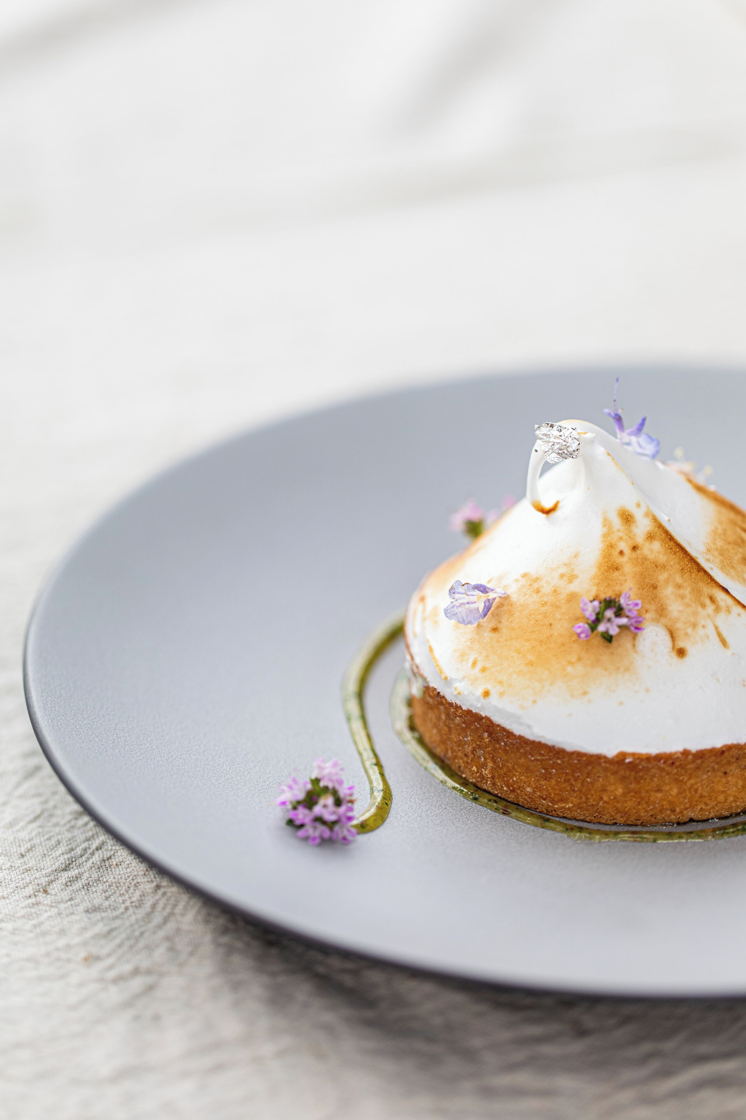 Un postre en un plato con una pequeña flor como adorno.