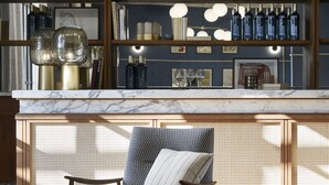 A bar area with wooden shelves, hanging pendant lights, and a marble countertop. - Ultimate Provence Hotel & Spa Golfe de Saint Tropez (La Garde-Freinet)