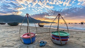 Una spiaggia con barche e un tramonto.