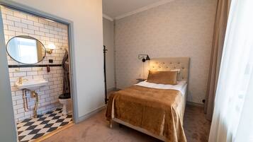 Une chambre à coucher avec un lit, une lampe de chevet, une table de chevet et un miroir.
