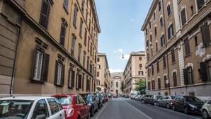 A street lined with parked cars and historic buildings with uniform architecture. - Grandis Rooms (Rome)