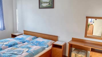 A bedroom with a wooden bed, a nightstand, a bedside table, a small cabinet, and a mirror.