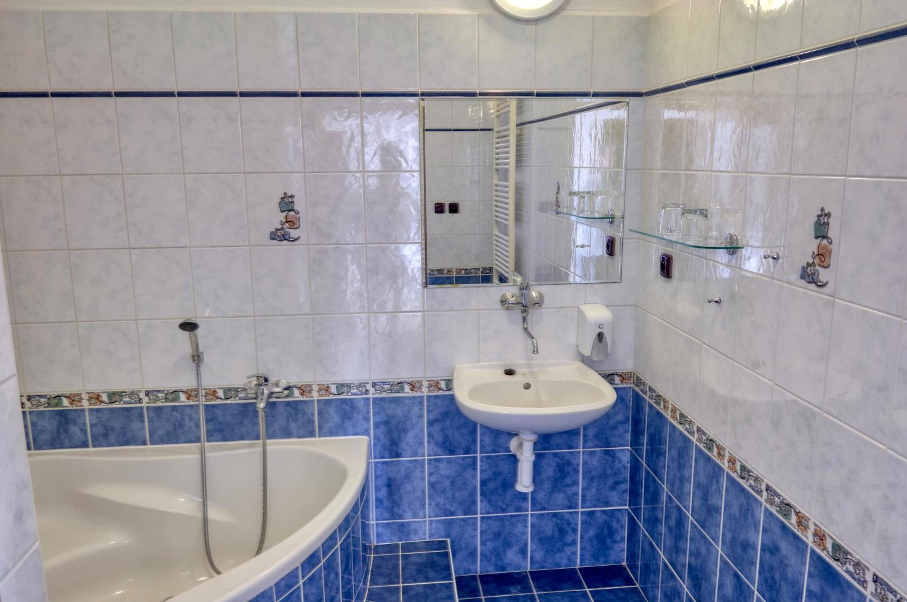 Un baño con bañera, lavamanos y espejo.