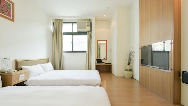 A hotel room with two beds, a desk with a computer, a TV, and a window with curtains. - Raise Hotel Taichung (Taichung)