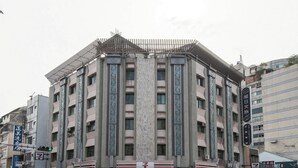 A multi-story building with a central column, multiple balconies, and a 7-Eleven store at the ground level. - Raise Hotel Taichung (Taichung)